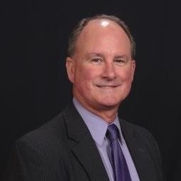 Portrait of Rob Torgusen wearing a suit and purple tie, used in testimonial section