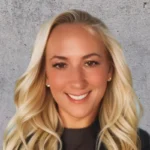 Portrait of Renee Pillo, smiling against a textured wall background