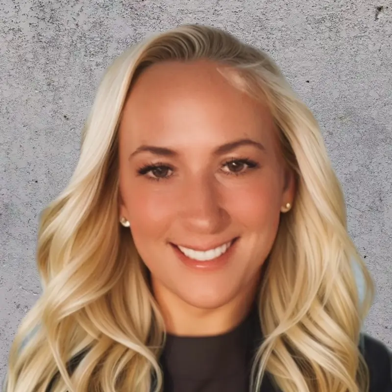 Portrait of Renee Pillo, smiling against a textured wall background