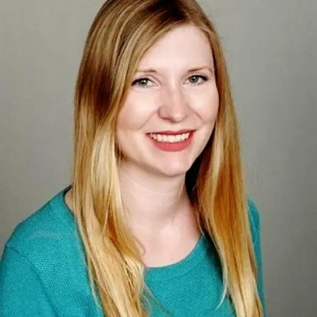 Portrait of Andrea K. Whalen smiling in front of a light background